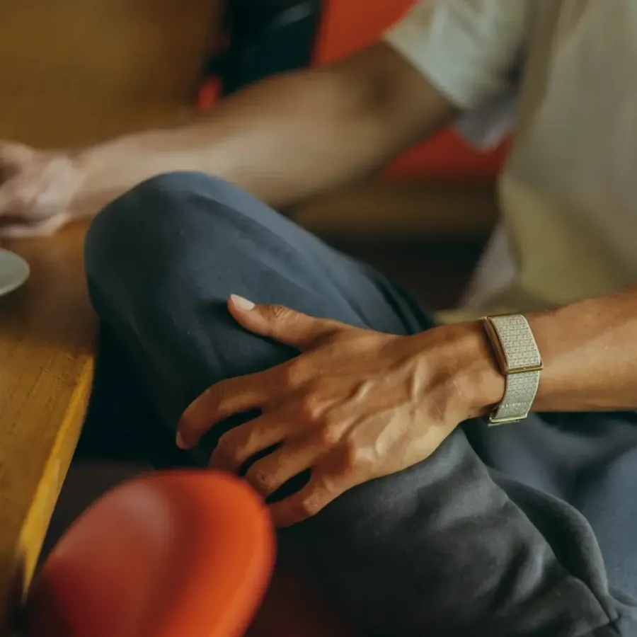 Hand resting on a knee, a light Polar Loop on the wrist