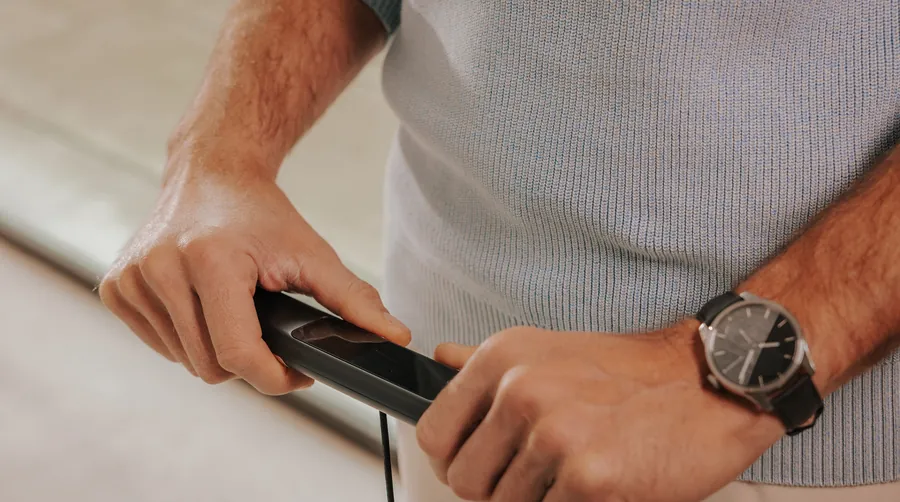 Both hands holding the retractable handle of the Withings BodyScan 2